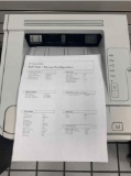 desktop laser printers with test pages printed out to verify print quality.