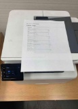 desktop laser printers with test pages printed out to verify print quality.