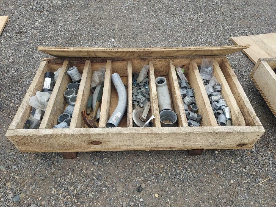 Wooden crate full of metal piping pieces.