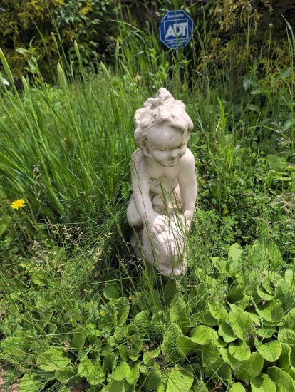 Child on fish cement lawn ornament