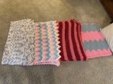 four crocheted afghans, pillows