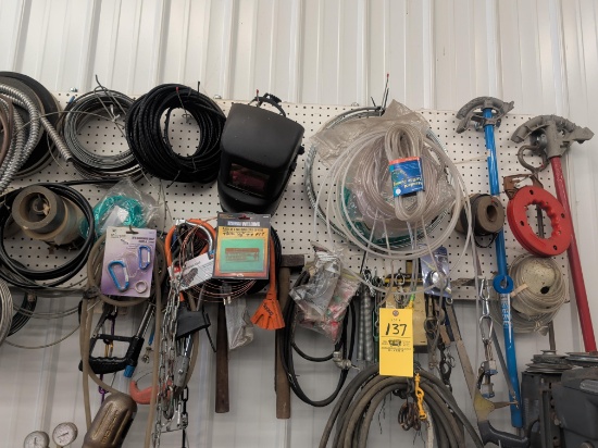 Contents of garage wall pegboard: pipe benders, mallets, hacksaws and more