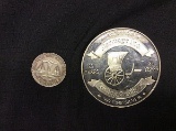 1 big coin that says one pound carriage inc,point 999 silver, 1 coin says one troy ounce silver trad