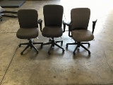 Three grey office chairs