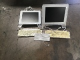 Two apple computer monitors with three keyboards