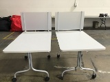 Two rectangular white tables with privacy partition