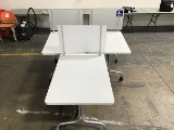 Three rectangular white tables with privacy partition