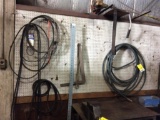 Contents on pegboard: weed trimmer; hose; belts.