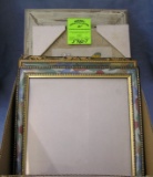 Box full of vintage picture frames some with artwork