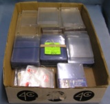 Box full of trading card protective cases and sleeves