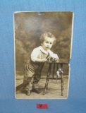 Early photo post card featuring a young boy with toys