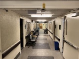 FLR 1: CONTENTS OF MAIN CORRIDOR: ASSORTED SEATING, PORTABLE CARTS, SPACE HEATERS,
