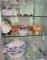 Three shelves of antique collectibles including hat pins and more