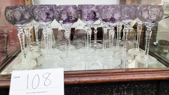 Eight crystal water goblets (or flutes) and 14 purple crystal wine glasses