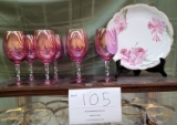 Seven cranberry wine glasses and floral plate
