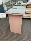 Display case, mirrored back doors, square glass top, pink presswood base
