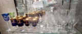 Shelf of blue/gold crystal goblets, crystal decanters, crystal pitcher