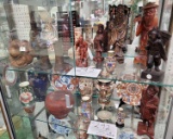 Two shelves of various Asian vases, wood figures