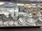 Shelves of various china, tea cups and milk glass