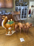 Four wood carved camels, one ceramic camel w/green drape