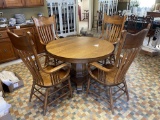Round oak pedestal table with four dining chairs