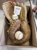 Two baseball gloves with two baseballs