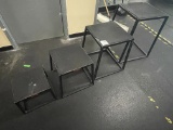 Four various sized black metal stepping tables