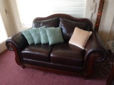 Brown leather love seat with throw pillows