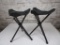 Two black canvas camp stools with carrying strap