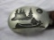 Canoe in wilderness metal belt buckle with artist signature on the back on a leather belt