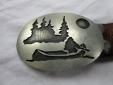 Canoe in wilderness metal belt buckle with artist signature on the back on a leather belt