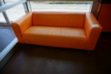 (1) Orange Faux Leather Couch.