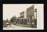 AMHERST JCT: RPPC of Brick Block to East at AMHERST JCT., WIS. Wagon headed