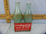 Double pop bottle carrier of shopping cart with two 6 oz. Coca-Cola bottles