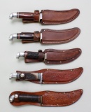 5 Western fixed blade knives in leather sheaths.