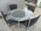 Modern glass top table with 4 leather chairs in excellent condition.