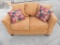 Burnt orange suede loveseat in used condition with no tears.