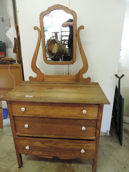 Antique oak dresser with mirror and white porcelain hardware.
