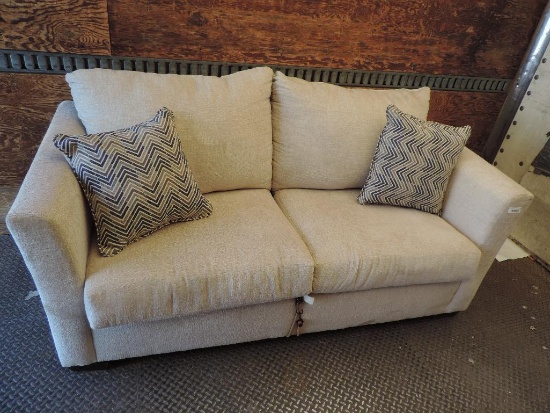 Tan upholstered hide-a-bed sofa in good condition with 2 throw pillows.
