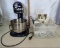 Blue kitchen Aid mixer with accessories and manual.
