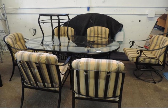 Black metal oval patio table with 6 chairs, side table and cushions.