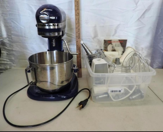 Blue kitchen Aid mixer with accessories and manual.