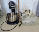 Blue kitchen Aid mixer with accessories and manual.