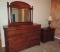 Cherry wood dresser with mirror, matching nightstand and lamp.