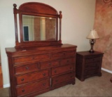 Cherry wood dresser with mirror, matching nightstand and lamp.