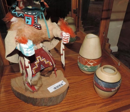 Kachina doll with two southwestern vases.
