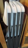 Four white plastic Lifetime folding chairs.