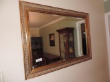 Two gold framed mirrors.