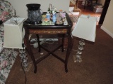 Ornate mirrored top side table with lamps and glass flowers.