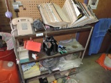 Metal shelf with parts catalogs & vintage phone.